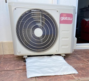 FloodSax sandless sandbags soaking up water dripping from an air conditioning unit
